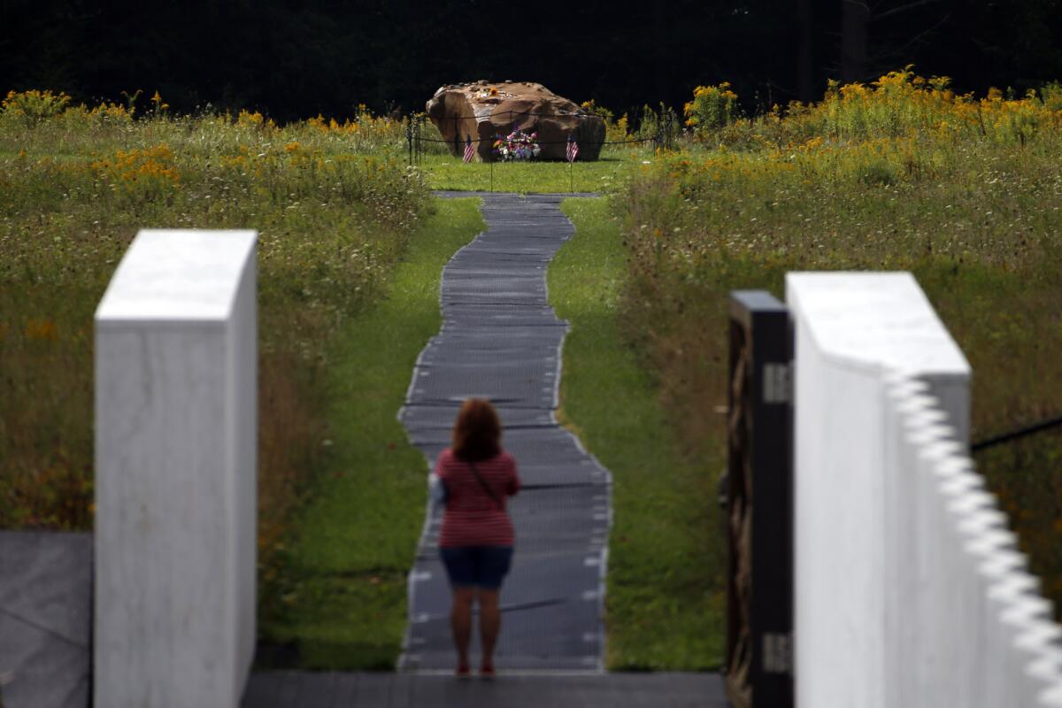 A visitor takes a picture of the boulder that marks the crash site of United Flight 93 after a service of remembrance at the Flight 93 National Memorial in Shanksville, Pa., on Friday.