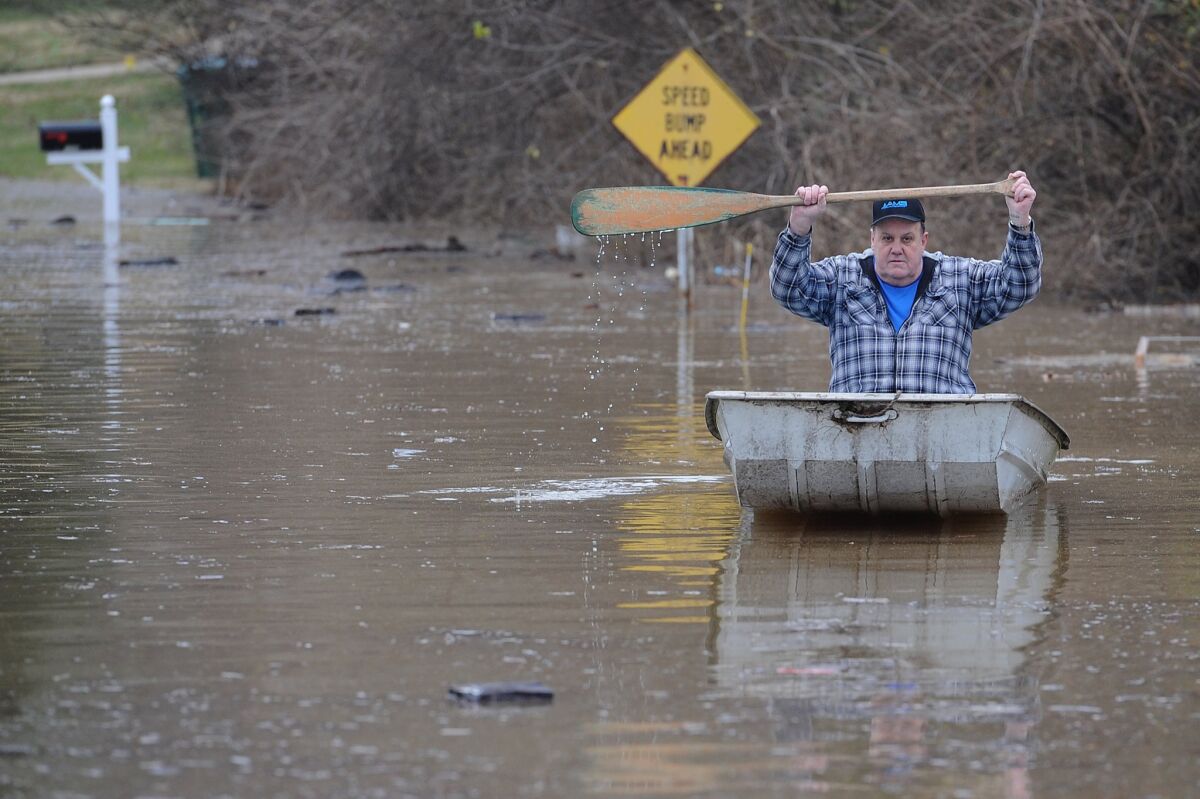 A resident canoes down a street flooded by the Meremac River in Arnold, Mo.