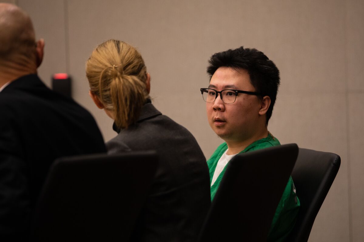 Yuhao Du, 25, speaks to his attorneys at the San Diego Central Courthouse on Nov. 18, 2022.