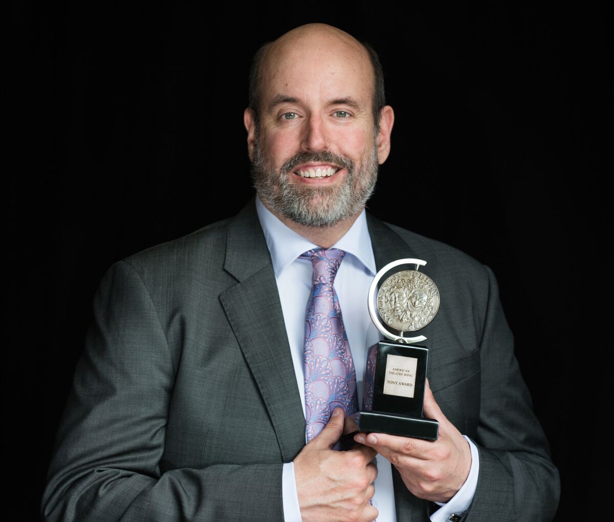 La Jolla Playhouse artistic director Christopher Ashley holding the Tony Award for directing "Come from Away."