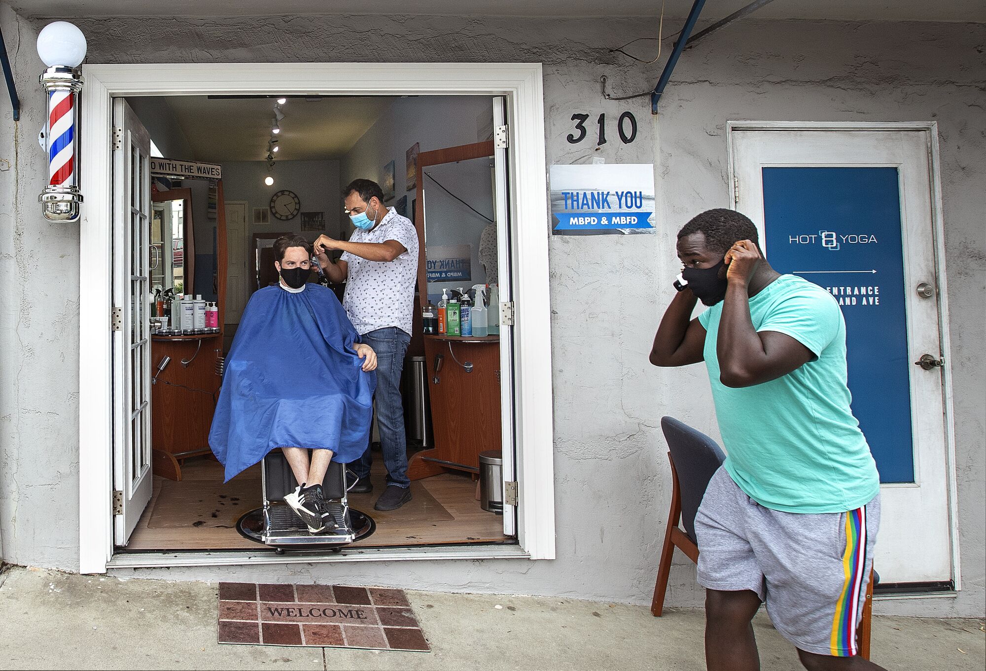 Faro Tabaja, owner of Waves Barbershop & Boutique in Manhattan Beach, works on a client.
