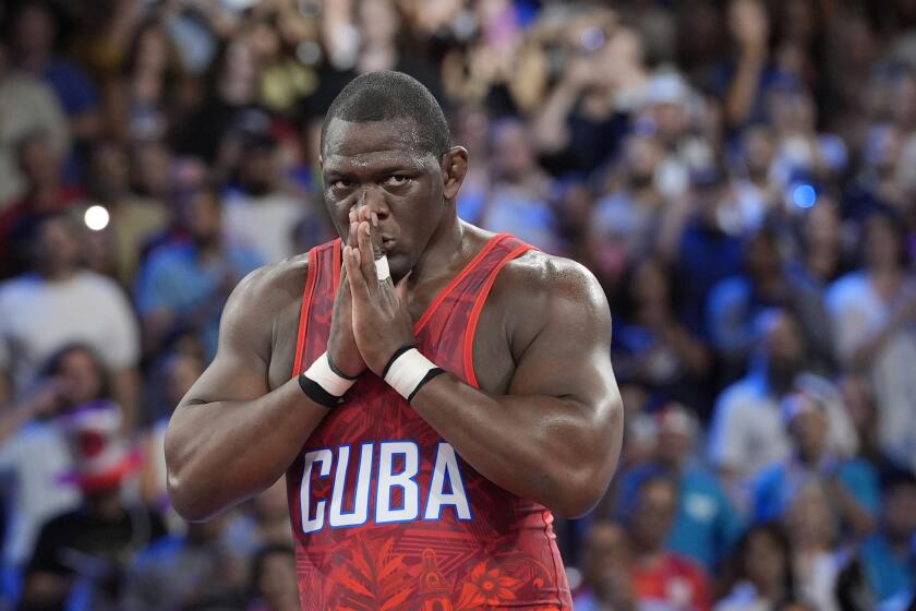 El cubano Mijaín López celebra tras derrotar al chileno Yasmani Acosta en la final de los 130 kilogramos de la lucha grecorromana de los Juegos Olímpicos de París, el martes 6 de agosto de 2024. (AP Foto/Eugene Hoshiko)