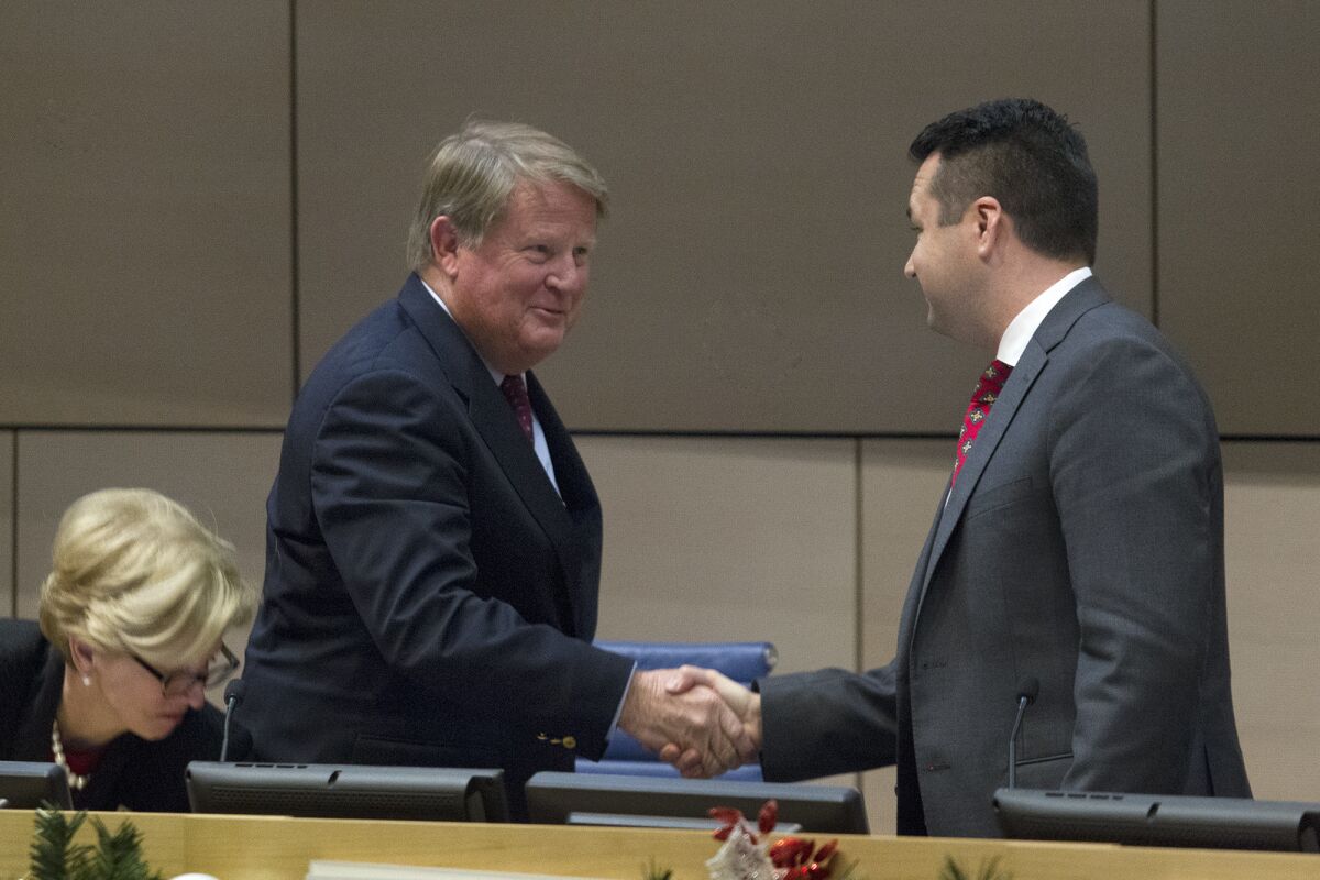 New Mayor Pro Tem Marshall "Duffy" Duffield, left, is congratulated on his new council position by new Mayor Kevin Muldoon at Newport Beach City Hall on Tuesday.