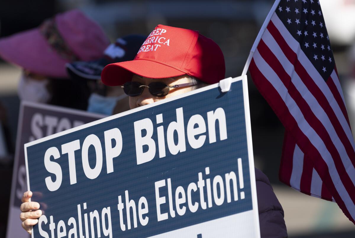 Una mujer en un acto a favor del presidente Donald Trump' alza un cartel 