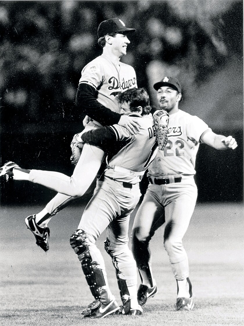 Rick Dempsey lifts Orel Hershiser after winning the 1988 World Series as Franklin Stubbs rushes in. 