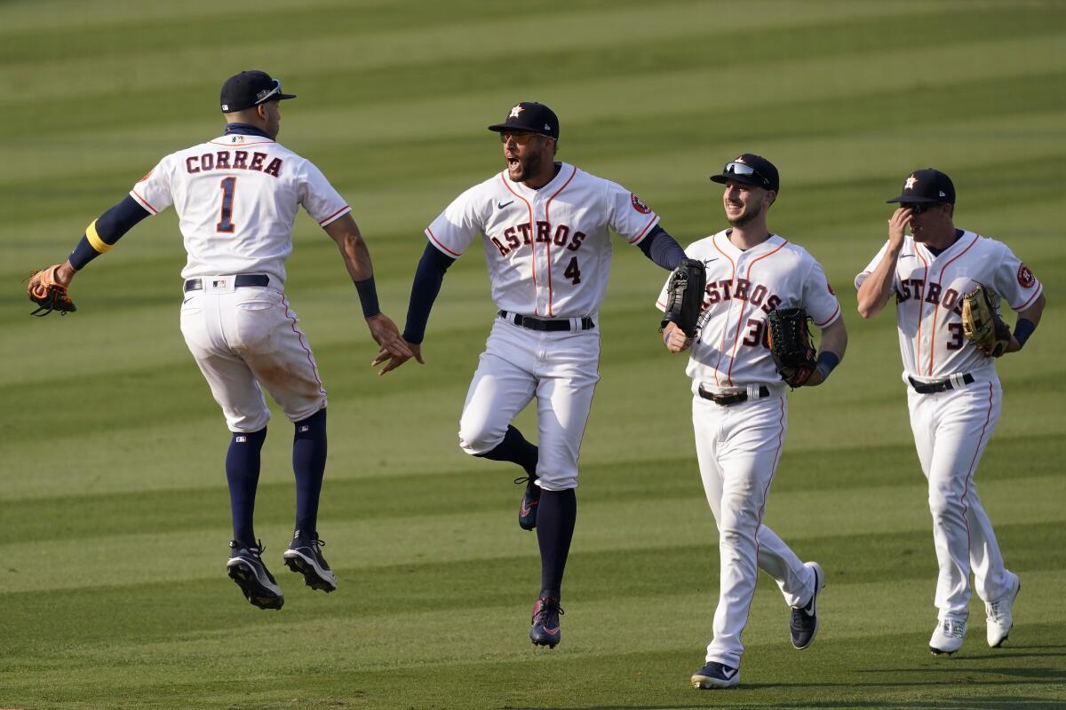 Houston Astros' Carlos Correa, from left, celebrates with George Springer, Kyle Tucker and Myles Straw.