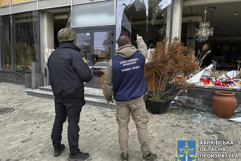 En esta imagen proporcionada por la fiscalía regional de Járkiv, fiscales de crímenes de guerra inspeccionan la escena tras un ataque ruso en Járkiv, Ucrania, el miércoles 24 de abril de 2024. (Fiscalía regional de Járkiv/ via AP)