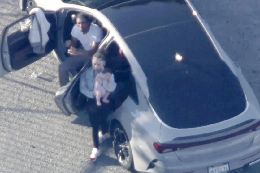 A female passenger in a suspect car that led police in chase seen exiting the vehicle with an infant on July 17, 2024. 