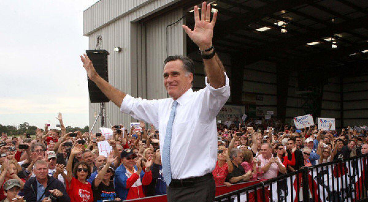 Republican presidential candidate Mitt Romney responds to cheering supporters at an airport rally in Kissimmee, Fla.