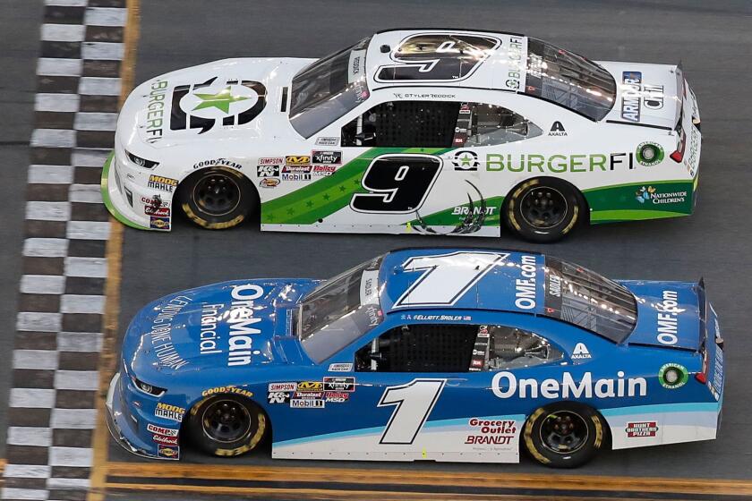 Tyler Reddick (9) crosses the finish line ahead of Elliott Sadler (1) to win the NASCAR Xfinity Series auto race at Daytona International Speedway, Saturday, Feb. 17, 2018, in Daytona Beach, Fla. (AP Photo/John Raoux)