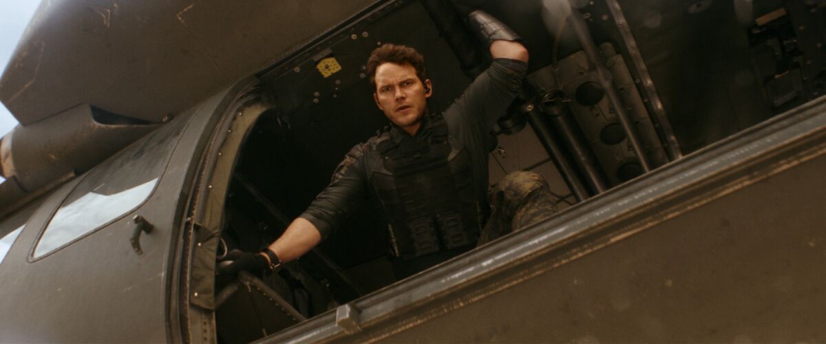 Chris Pratt's character looks out the open door of a military helicopter in the movie “The Tomorrow War”