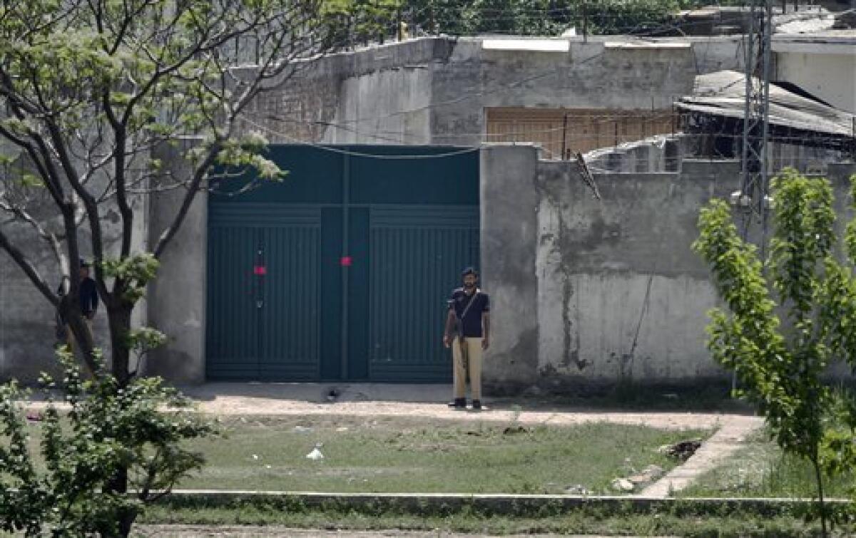 Pakistani police officers stand guard at the main gate of a house where al-Qaida leader Osama bin Laden was caught and killed in Abbottabad, Pakistan on Wednesday, May 4, 2011. The residents of Abbottabad, Pakistan, were still confused and suspicious on Wednesday about the killing of Osama bin Laden, which took place in their midst before dawn on Monday. (AP Photo/Anjum Naveed)