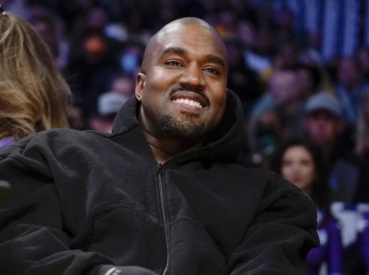Kanye West smiling in a black jacket