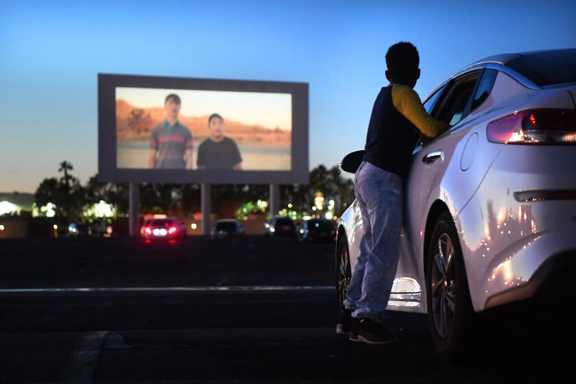 PARAMOUNT, CALIFORNIA MARCH 17, 2020-Michael Ray, 11, watches a trailer before a movie at the Paramount Drive-In. (Wally Skalij/Los Angeles Times)