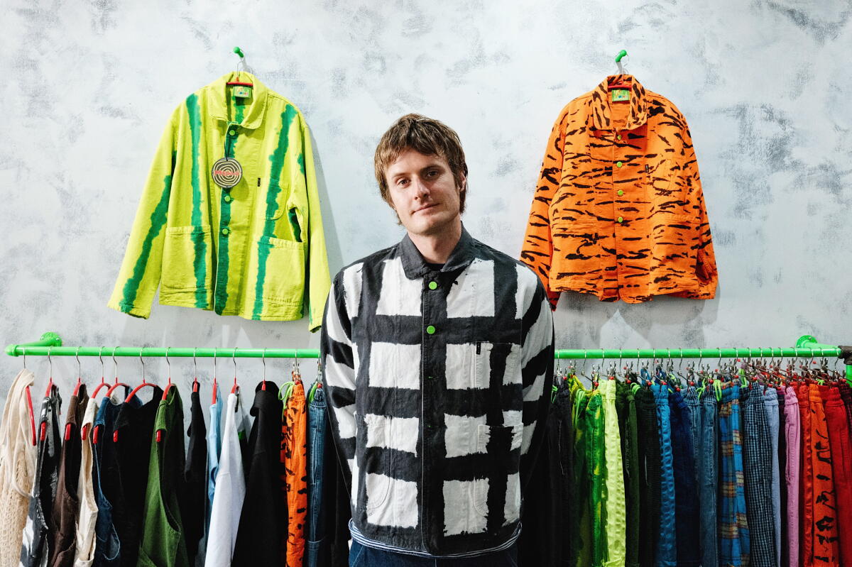 Meals Clothing co-founder Sam Salad stands amid his food-inspired, L.A.-made workwear successful his Highland Park shop