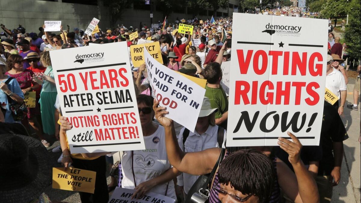 Demonstrators march through the streets of Winston-Salem, N.C., on July 13, 2015, after the beginning of a federal voting rights trial challenging a 2013 state law.