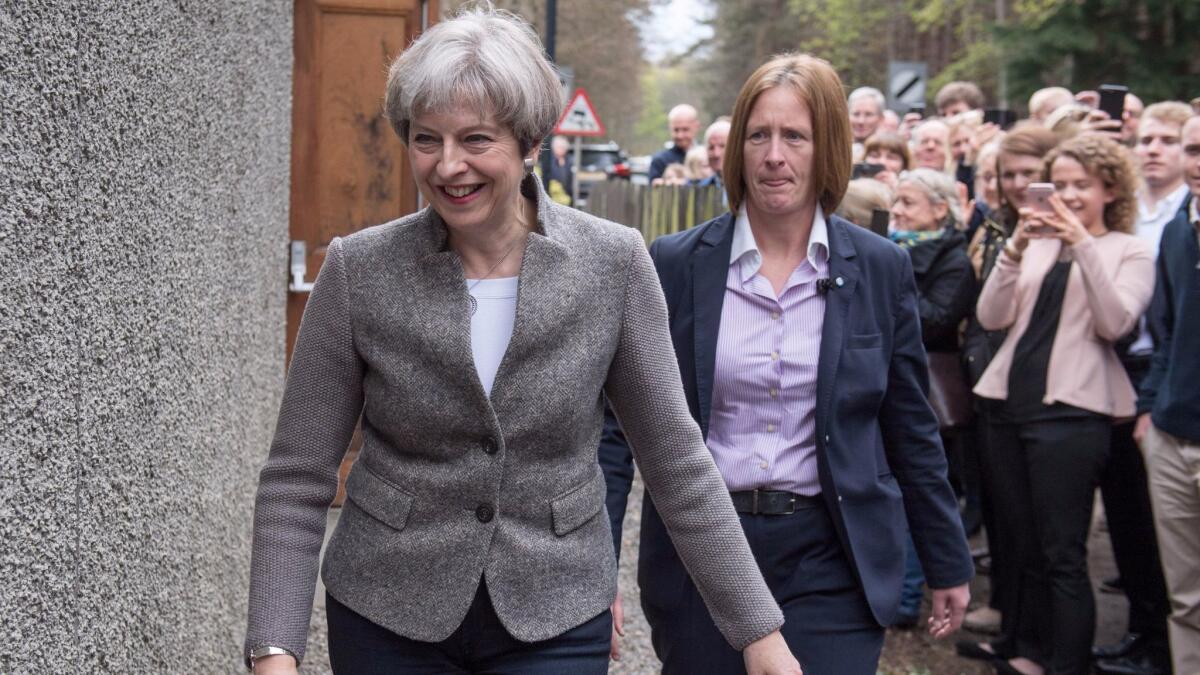 Britain's Prime Minister Theresa May, left, goes door to door campaigning for Andrew Bowie, Conservative candidate for West Aberdeenshire and Kincardine, in the village of Banchory, Scotland, on April 29, 2017.
