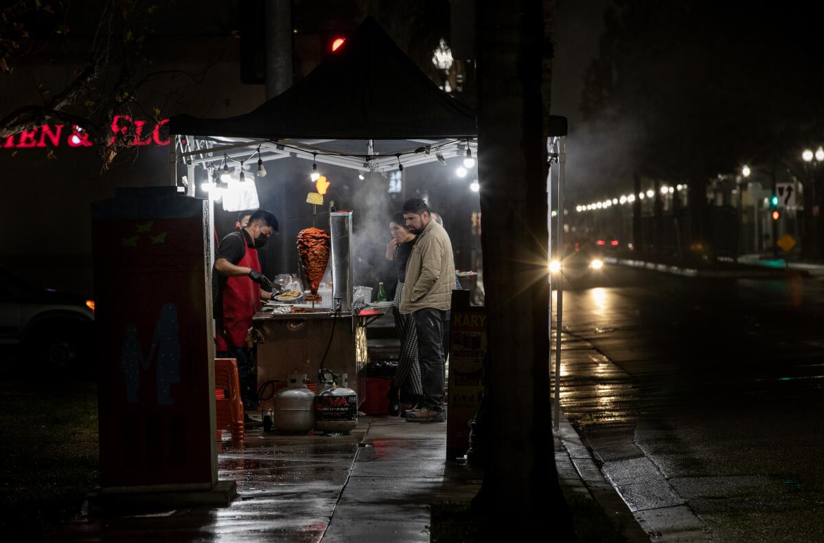 A street vendor sells food at night.