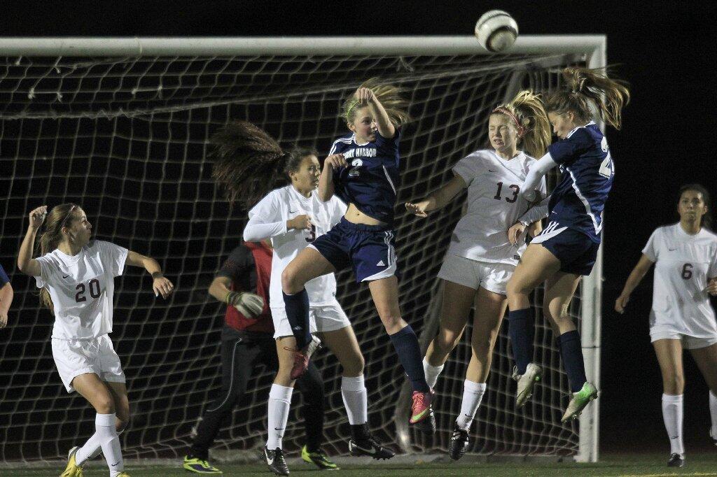 Newport Harbor High's Sianna Siemonsma, second from right, heads the ball in, on a corner kick, for a goal during the first half in a nonleague game against Estancia at Jim Scott Stadium on Thursday.