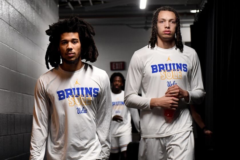 Sacramento California March 16, 2023-UCLA's Tyger Campbell, left, and Mac Etienne walk.