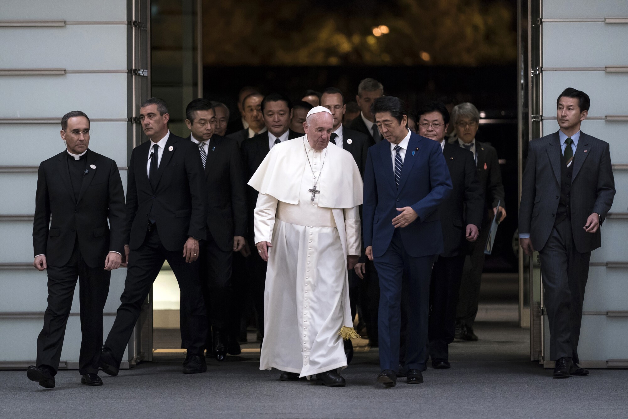 Pope Francis walks with Japan's Prime Minister Shinzo Abe as he arrives at the prime minister's official residence in Tokyo