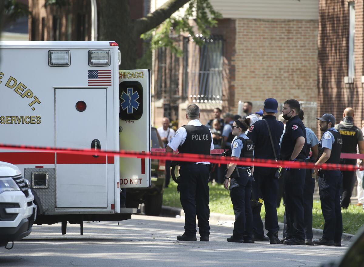 Chicago police and emergency medical personnel work at the scene of a police-involved shooting in Chicago, Friday, July 9, 2021. Law enforcement officers in Chicago shot and wounded a 33-year-old man who pointed a gun at them as they tried to arrest him Friday, authorities said. (Antonio Perez/Chicago Tribune via AP)