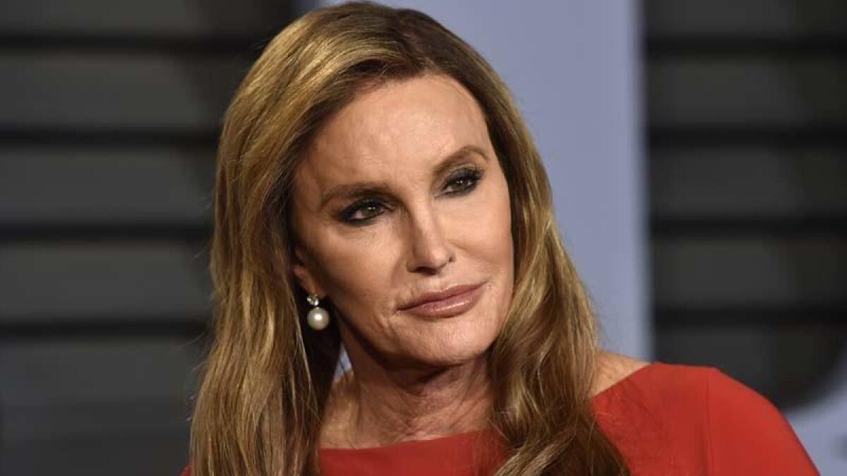 Caitlyn Jenner posing in pearl earrings and a red dress