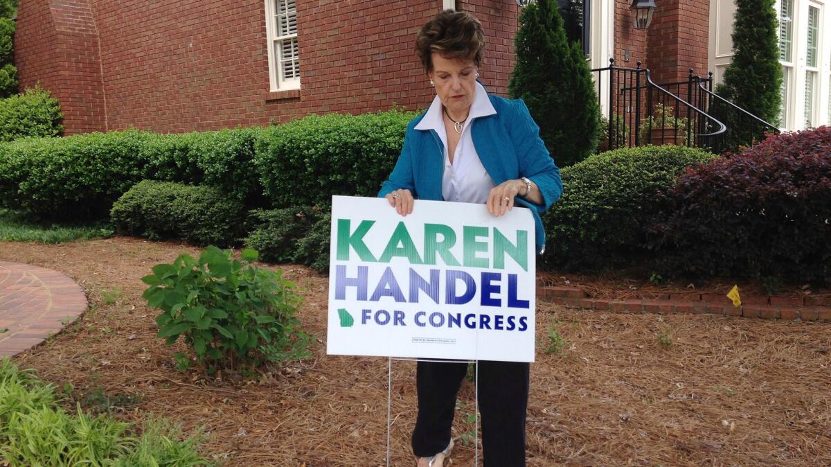 Bev Wingate places a Karen Handel campaign sign outside her home in Dunwoody, Ga.,on April 19, 2017.