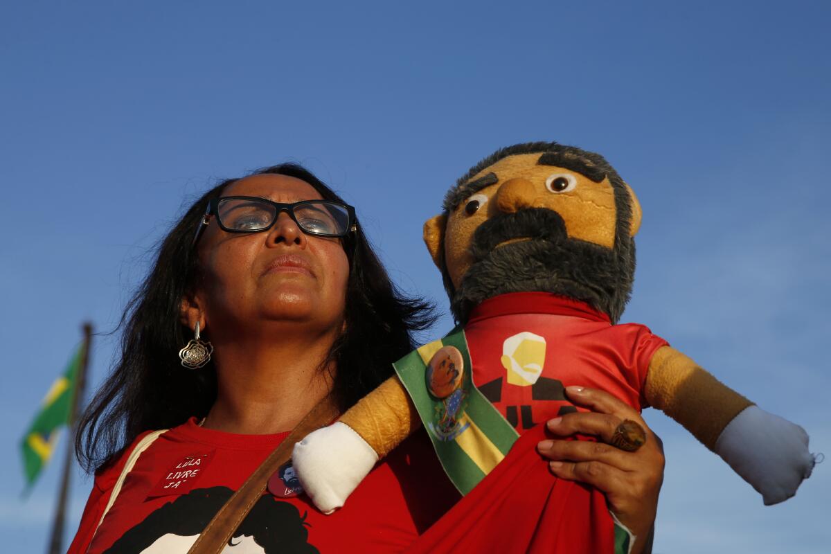 A supporter of Luiz Inácio Lula da Silva holds a doll depicting the former Brazilian president outside Brazil's Supreme Court in Brasilia on Thursday.