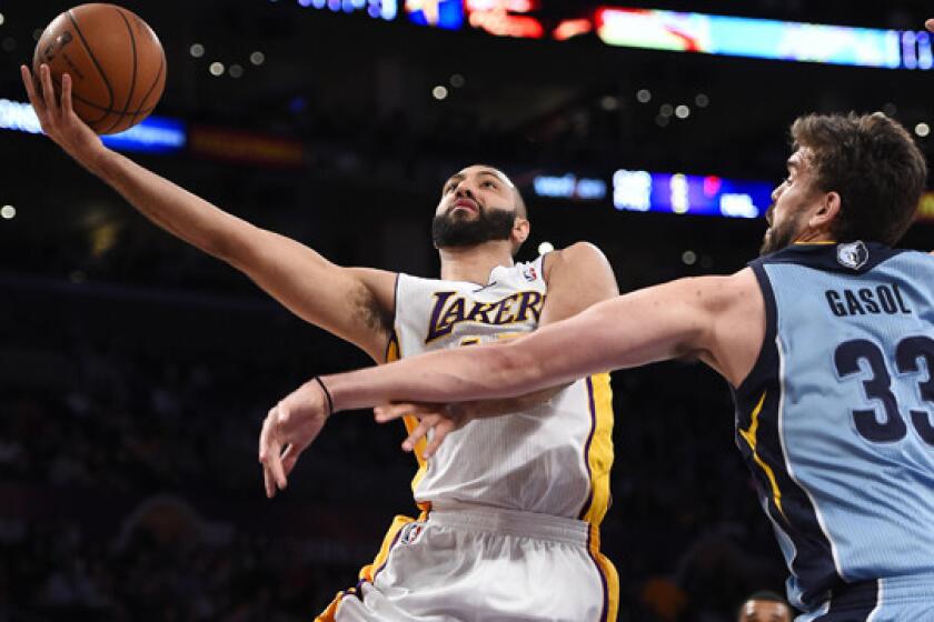Lakers point guard Kendall Marshall, left, puts up a shot in front of Memphis Grizzlies center Marc Gasol during a game last season at Staples Center.