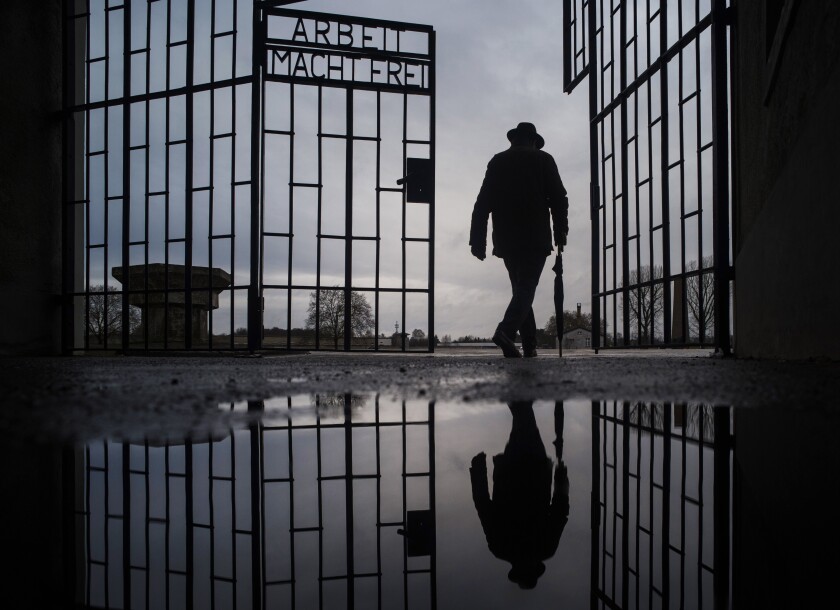 A man walks through the gate of the former Sachsenhausen camp.