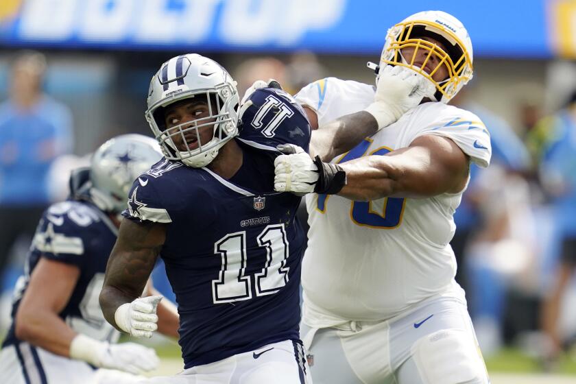 Dallas Cowboys linebacker Micah Parsons (11) is tackled by Los Angeles Chargers offensive tackle Rashawn Slater during the second half of an NFL football game Sunday, Sept. 19, 2021, in Inglewood, Calif. (AP Photo/Ashley Landis)