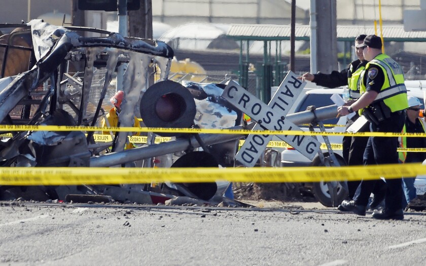 Police officers stand near a Metrolink train that hit a truck in February in Oxnard.