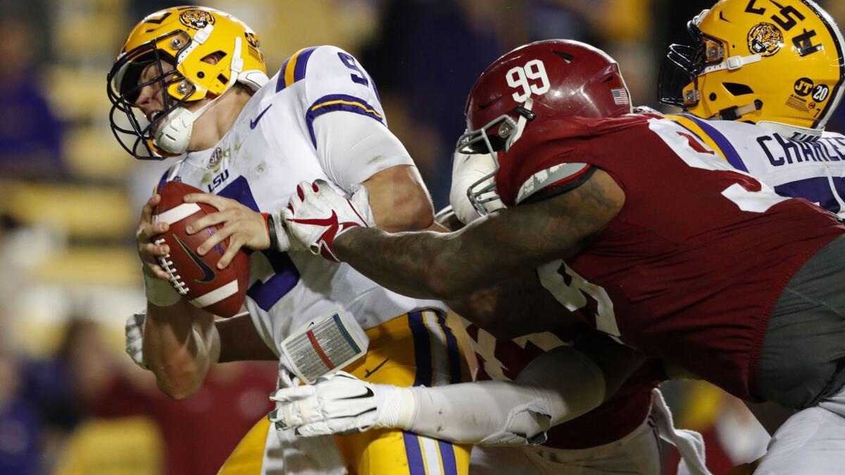 LSU quarterback Joe Burrow (9) tries to avoid a sack by Alabama defensive lineman Raekwon Davis (99) in the second half in Baton Rouge, La. on Nov. 3, 2018. Alabama won 29-0.