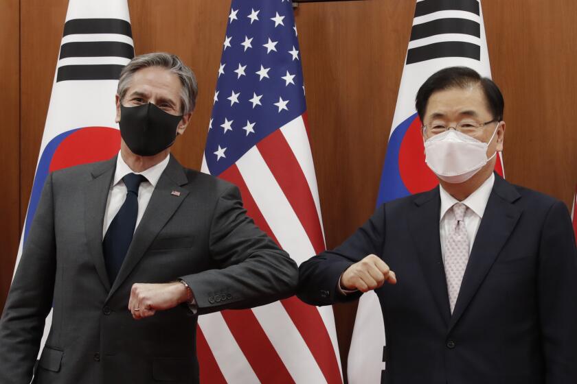 U.S. Secretary of State Antony Blinken, left, and South Korean Foreign Minister Chung Eui-yong, right, bump elbows.