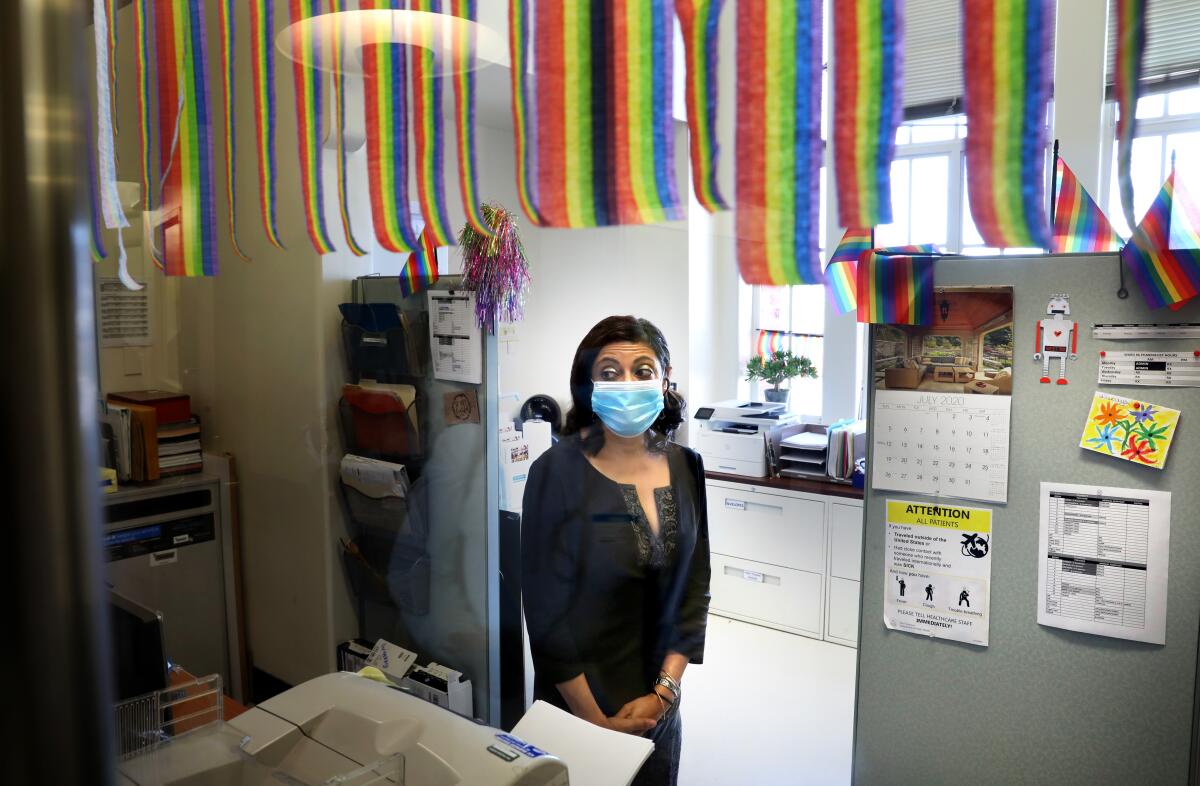 Dr. Monica Gandhi stands near cubicles 