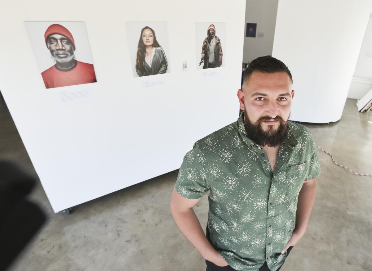 Photographer and homeless advocate Jordan Verdin poses for photos with his work.