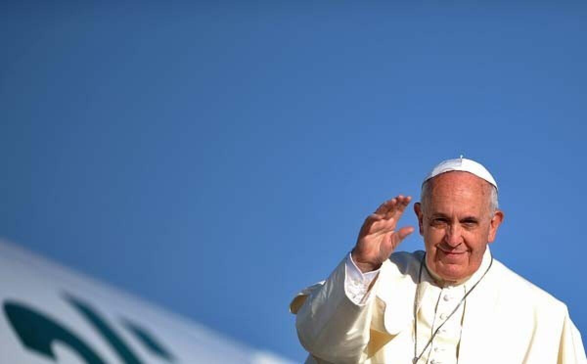 Pope Francis waves in 2014 outside a plane in Rome.