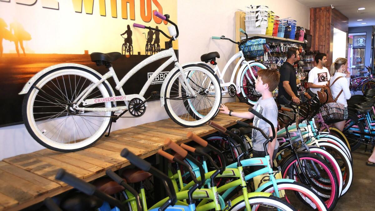 A youngster looks at a cruiser at the Easyrider bicycle shop in downtown Huntington Beach on Friday. The Huntington Beach Downtown Business Improvement District is using social media to bring more awareness to the area’s small businesses.