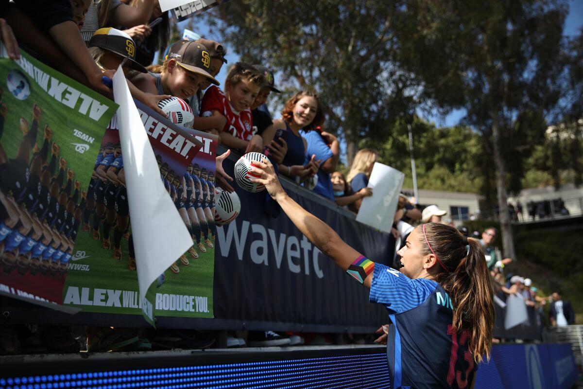 San Diego Wave FC forward Alex Morgan, signing autographs for a fan in June at Torero Stadium.