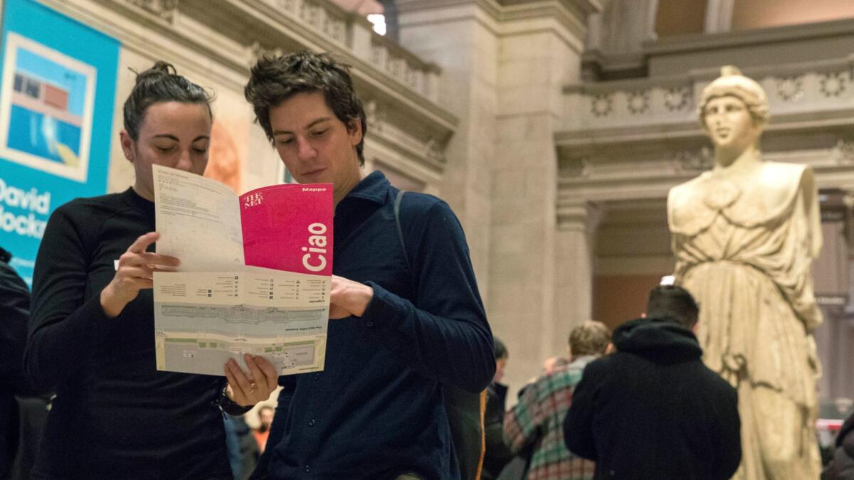 Visitors to the Metropolitan Museum of Art inspect a map of the galleries.