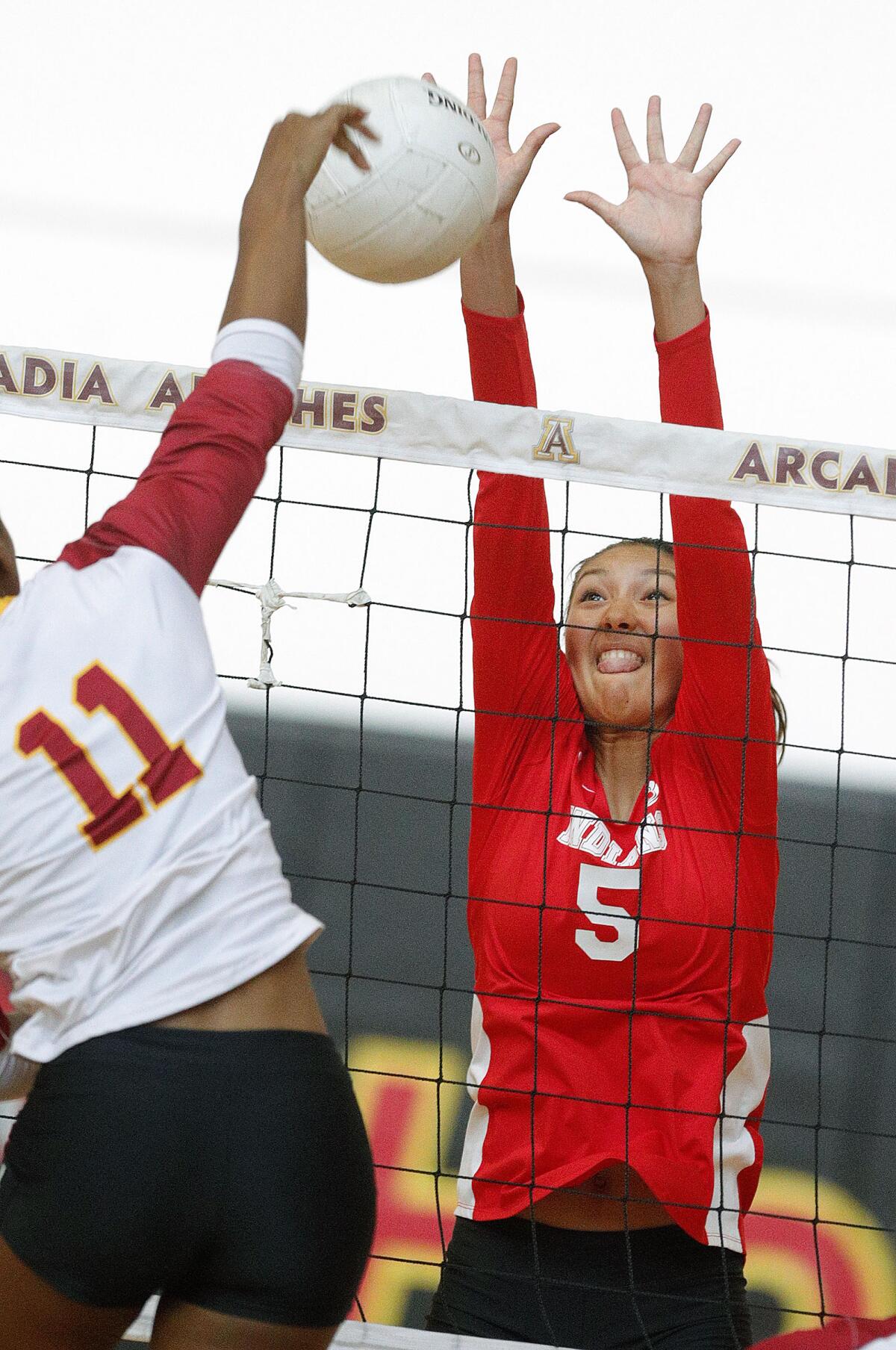 Burroughs' Camila Sanchez-Tellez reaches for the block against Arcadia's Monet Latundi in a Pacific League girls' volleyball match at Arcadia High School on Thursday, September 19, 2019. (Tim Berger / Staff Photographer)