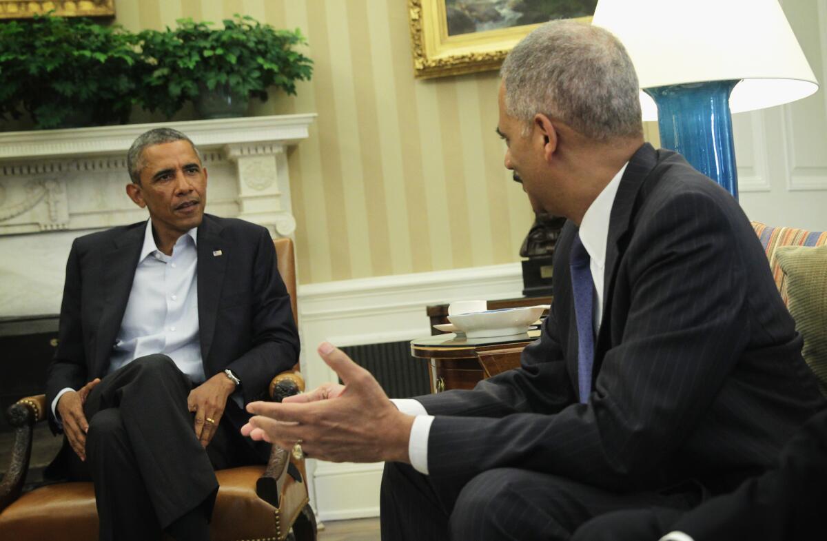 President Obama, left, is seen meeting with Attorney General Eric Holder in the Oval Office of the White House on Aug. 18, 2014.