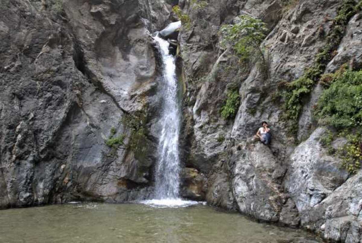 Sandra Gonzalez, 38, visiting from Mexico, takes a break at Eaton Canyon Falls in the Eaton Canyon Natural Area north of Pasadena in the Angeles National Forest. Officials warned hikers to stay clear from the area Tuesday.
