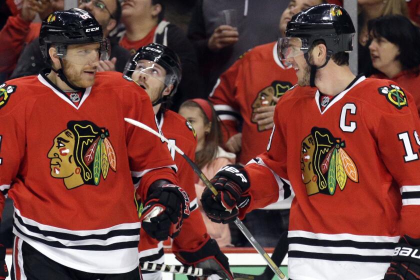 Chicago Blackhawks captain Jonathan Toews, right, smiles as he celebrates with teammate Marian Hossa (81) after scoring a first-period goal during the team's 4-1 win over the Minnesota Wild in Game 2 of the Western Conference semifinals Sunday.