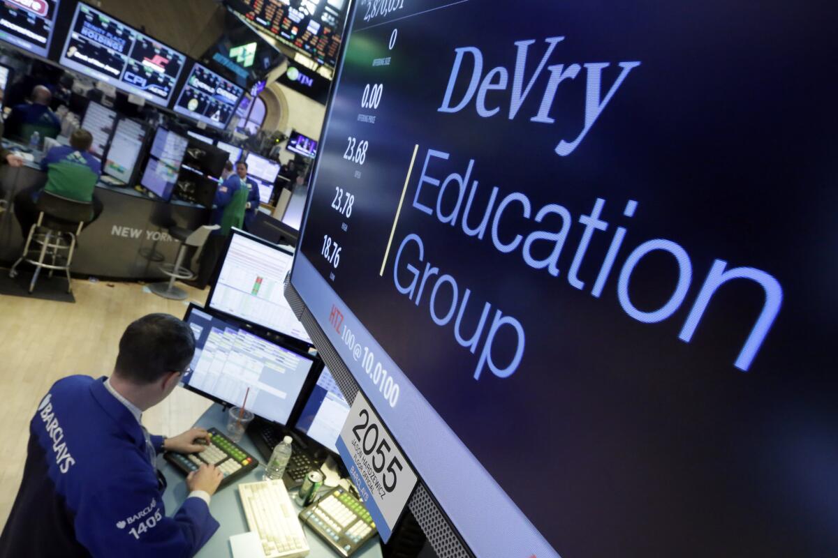 Specialist Neil Gallagher works at the post that handles DeVry Education Group on the floor of the New York Stock Exchange on Wednesday. The federal government is suing the operators of the for-profit DeVry University, alleging they misled consumers about students' jobs and earnings prospects.