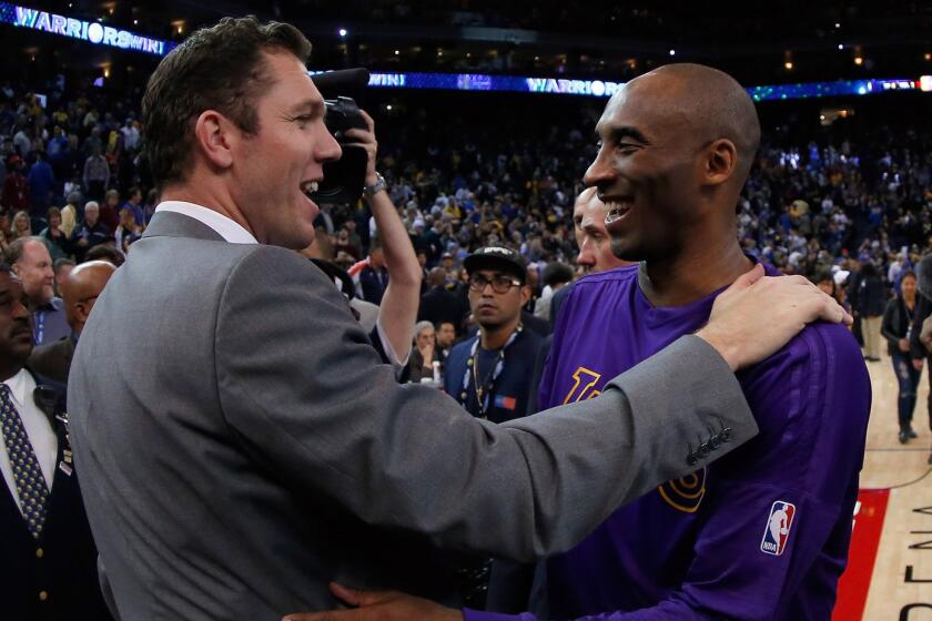 Los Angeles Lakers' Kobe Bryant hugs Golden State Warriors interim head coach Luke Walton after their game on Thursday.