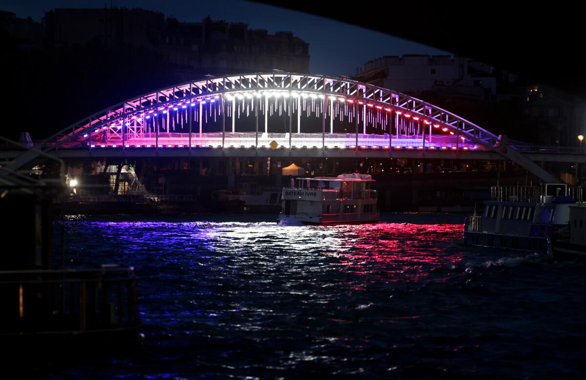 A bridge over the River Seine is illuminated days before the Olympics in Paris. 