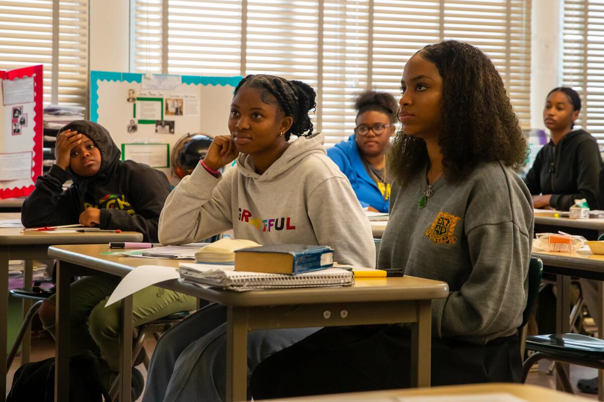 Students sit at their classroom desks. 