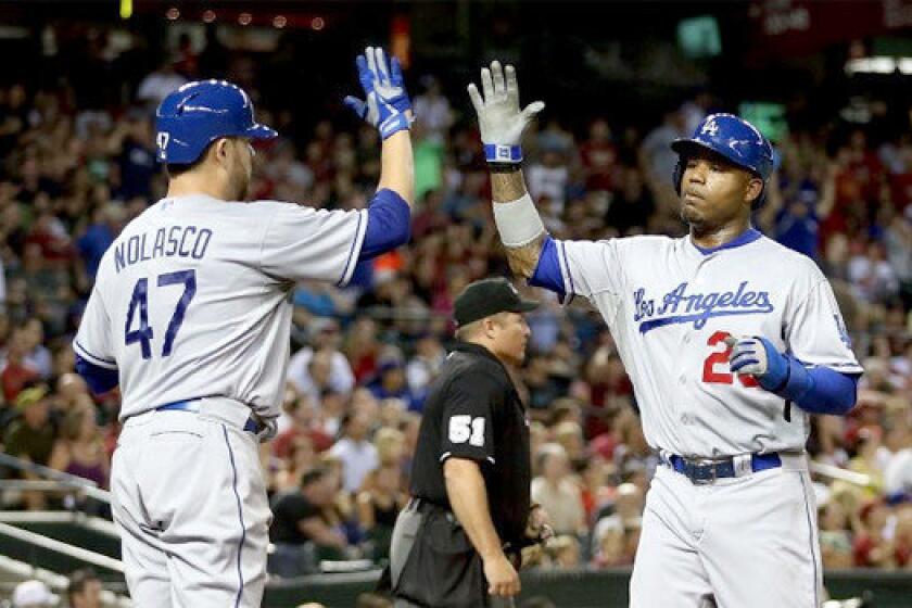 Ricky Nolasco high fives Carl Crawford after scoring in the fifth inning of the Dodgers' 6-1 victory over the Arizona Diamondbacks on Tuesday.
